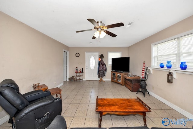 living room with light tile patterned floors, visible vents, baseboards, and ceiling fan