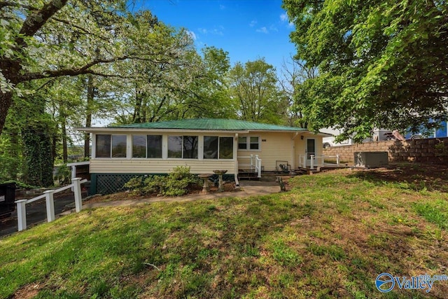 rear view of house featuring a yard, a sunroom, and fence