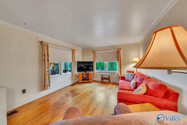 living room with crown molding, wood-type flooring, and visible vents
