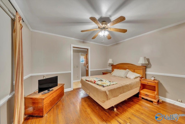 bedroom featuring crown molding, ceiling fan, wood finished floors, and baseboards