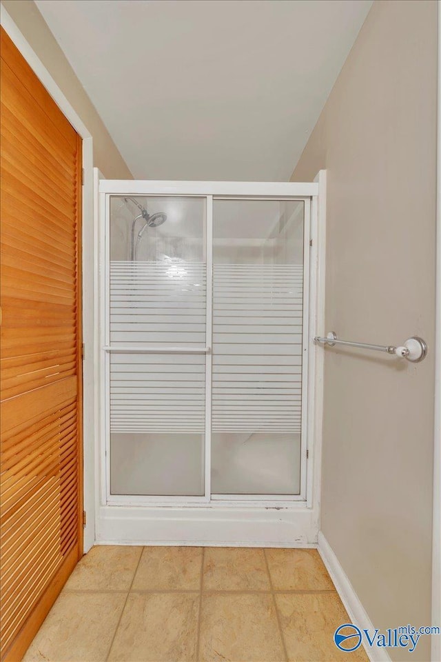 full bath with a shower stall and tile patterned floors