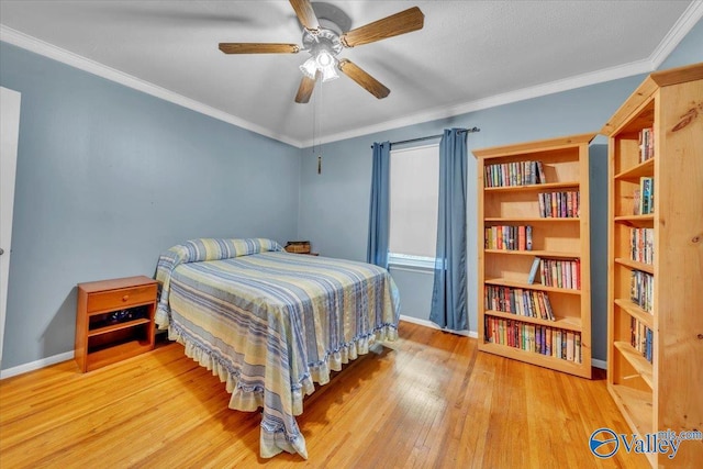 bedroom featuring crown molding, baseboards, and wood finished floors