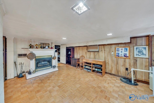 interior space featuring wood walls, baseboards, a fireplace with raised hearth, and recessed lighting