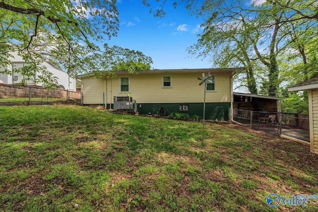 rear view of house featuring fence and a lawn