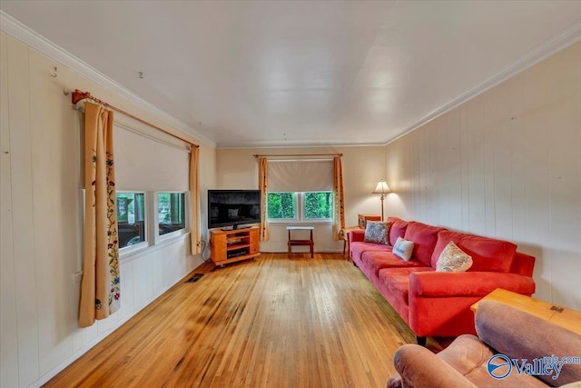living room with crown molding, visible vents, and hardwood / wood-style flooring
