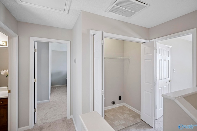 laundry area featuring visible vents, light colored carpet, attic access, and baseboards