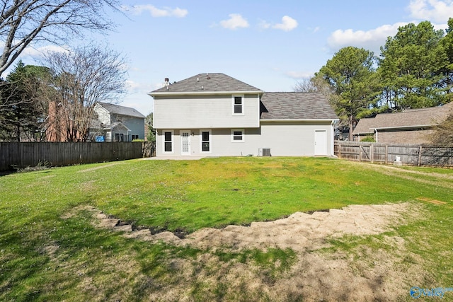 rear view of property featuring a lawn and a fenced backyard