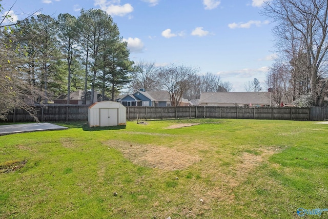 view of yard with an outbuilding, a fenced backyard, and a shed