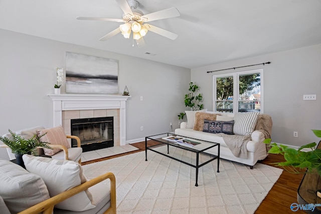 living area featuring visible vents, baseboards, wood finished floors, and a fireplace