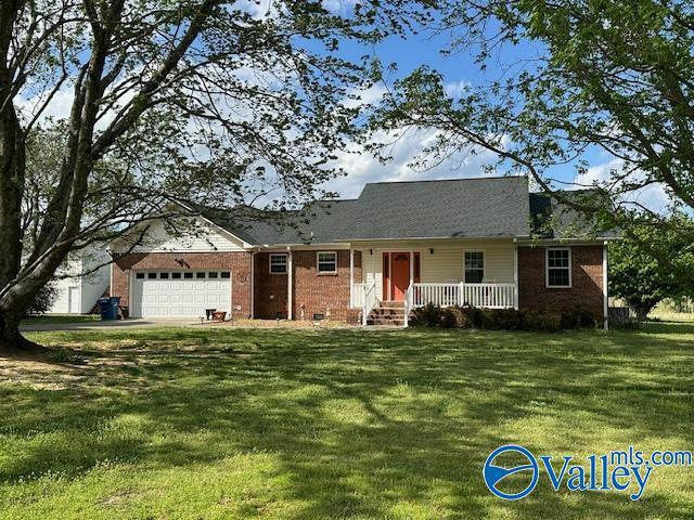 view of front of home with a garage, brick siding, and a front yard