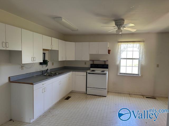 kitchen featuring white range with electric stovetop, visible vents, white cabinetry, a sink, and ceiling fan