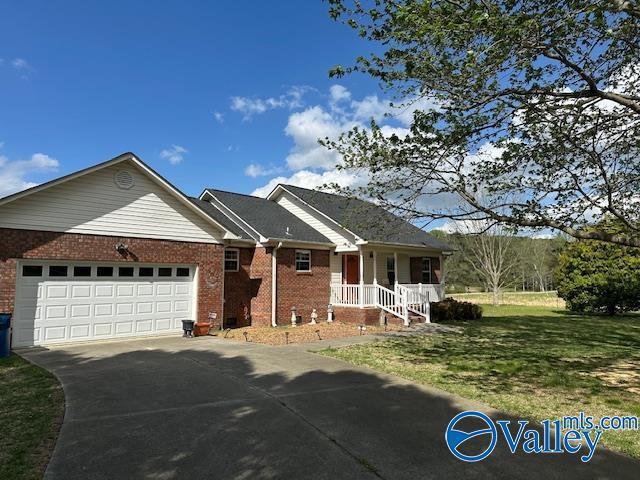 ranch-style home with brick siding, a front yard, concrete driveway, and a garage
