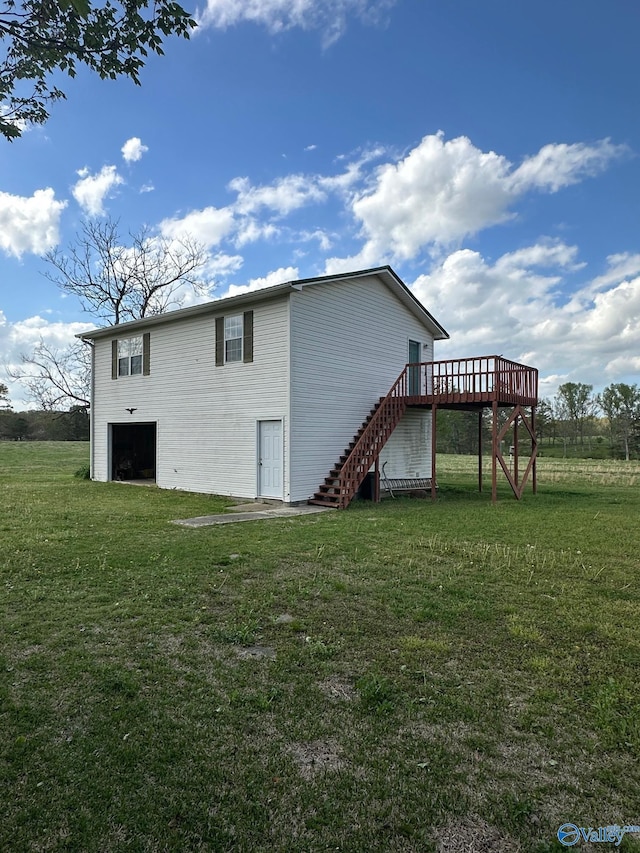 view of property exterior with stairway, a wooden deck, and a lawn