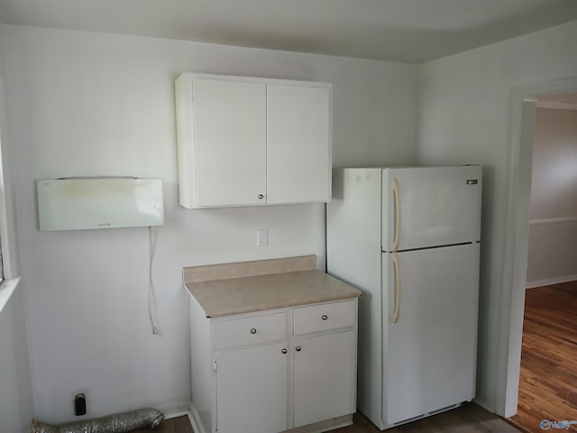 kitchen with wood-type flooring, white refrigerator, and white cabinets