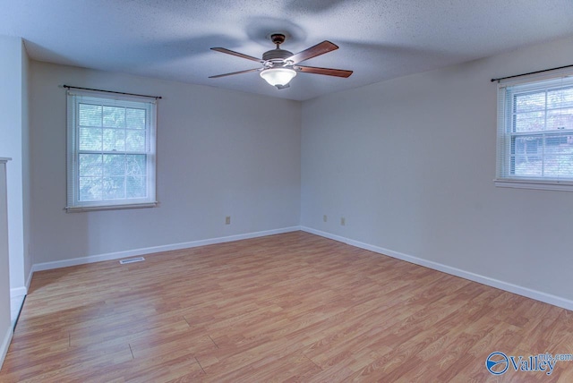 spare room featuring a textured ceiling, light hardwood / wood-style floors, and ceiling fan