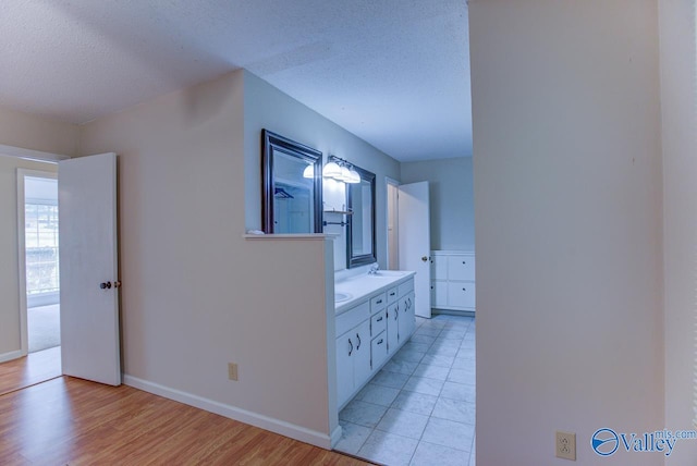 bathroom with wood-type flooring, a textured ceiling, and vanity