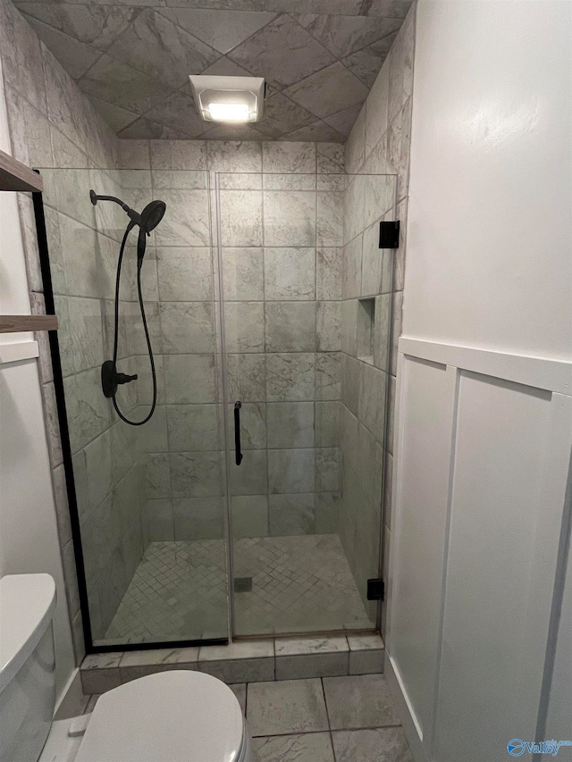 bathroom with a shower with shower door and toilet