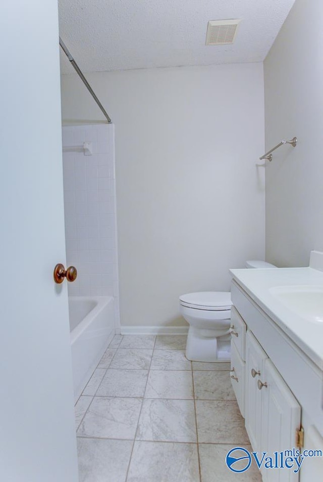 full bathroom with  shower combination, vanity, toilet, and a textured ceiling