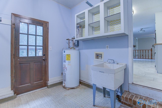 washroom with washer hookup, water heater, and a textured ceiling