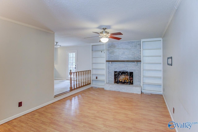 unfurnished living room with a brick fireplace, light hardwood / wood-style floors, ceiling fan, and a textured ceiling