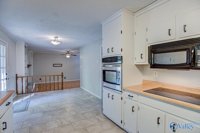 kitchen featuring ceiling fan, white cabinets, a textured ceiling, black appliances, and crown molding