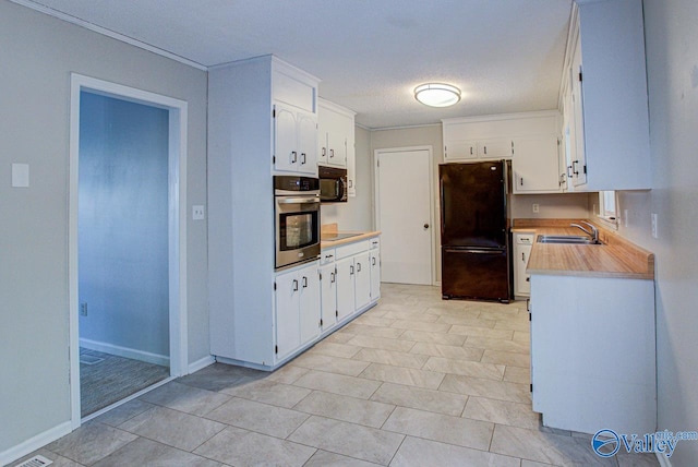 kitchen with ornamental molding, sink, a textured ceiling, white cabinetry, and black appliances