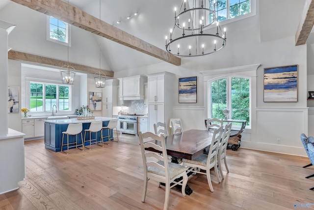 13559 Monte Vedra Rd SE, Huntsville, AL 35803 - dining space featuring a chandelier, high vaulted ceiling, light wood-style floors, a wainscoted wall, and a decorative wall