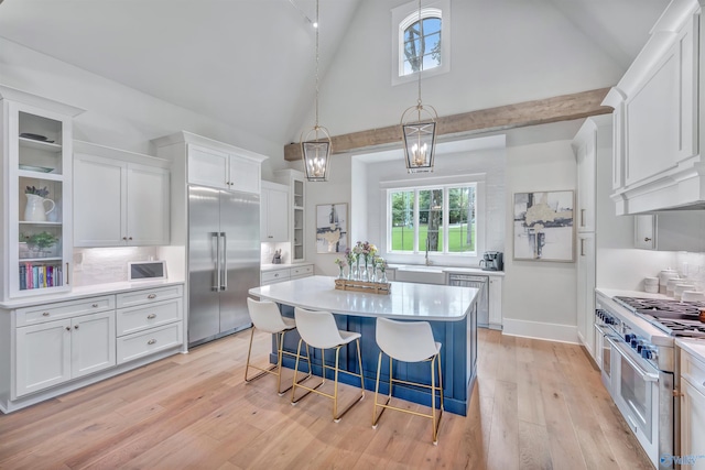 13559 Monte Vedra Rd SE, Huntsville, AL 35803 - kitchen featuring premium appliances, white cabinets, light countertops, a kitchen island, and high vaulted ceiling