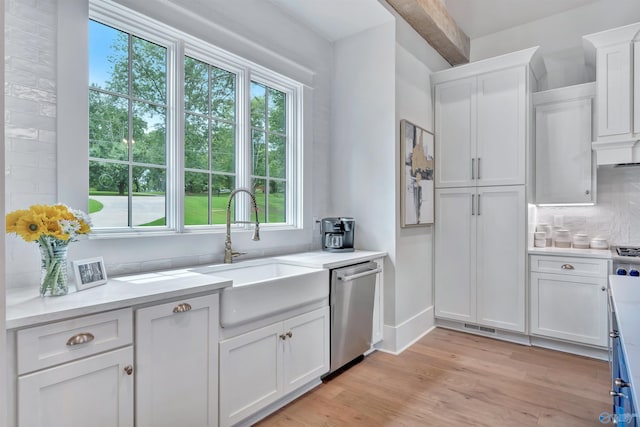 13559 Monte Vedra Rd SE, Huntsville, AL 35803 - kitchen with stainless steel dishwasher, white cabinets, light wood-type flooring, backsplash, and light countertops