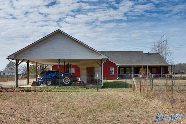 view of front of house featuring an attached carport, fence, and a front lawn