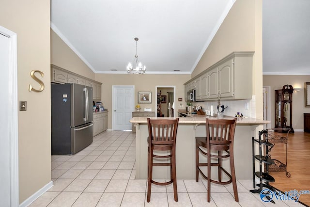 kitchen with a peninsula, gray cabinets, stainless steel appliances, and light countertops