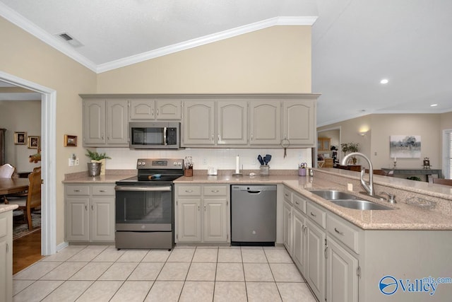 kitchen with light tile patterned floors, a peninsula, stainless steel appliances, crown molding, and a sink