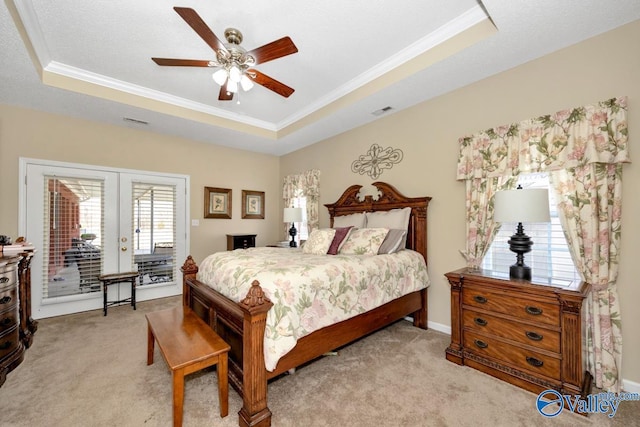 carpeted bedroom featuring access to exterior, ornamental molding, a raised ceiling, and french doors