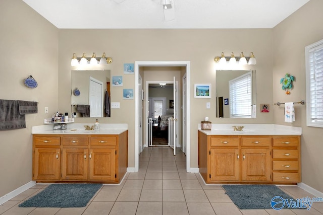 full bath featuring tile patterned flooring, two vanities, and baseboards