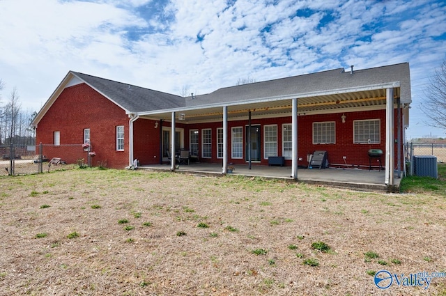 back of house featuring brick siding, a patio area, and fence