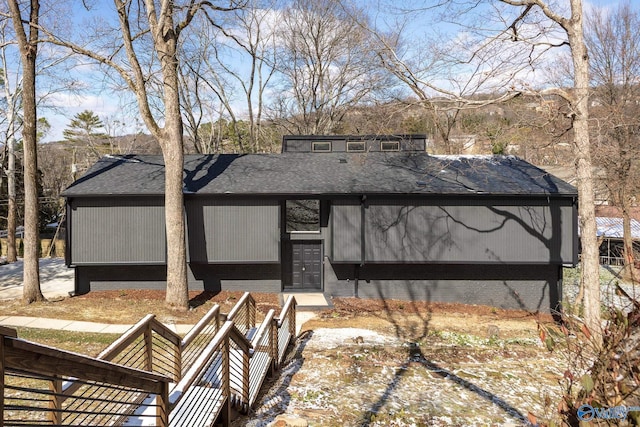 back of house with roof with shingles