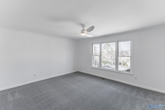 spare room with baseboards, ornamental molding, dark colored carpet, and a ceiling fan