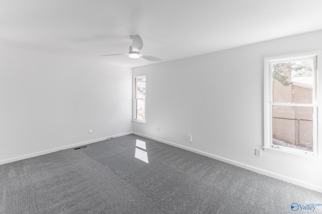 unfurnished room featuring carpet, visible vents, ceiling fan, and baseboards