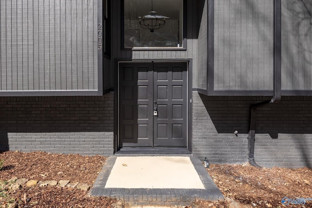 doorway to property featuring brick siding