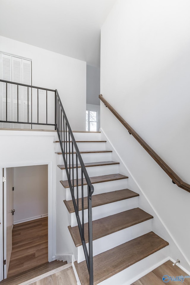 stairway featuring baseboards and wood finished floors