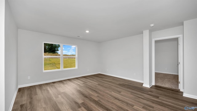 unfurnished room with dark wood-type flooring