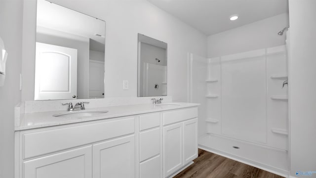 bathroom with vanity, wood-type flooring, and walk in shower