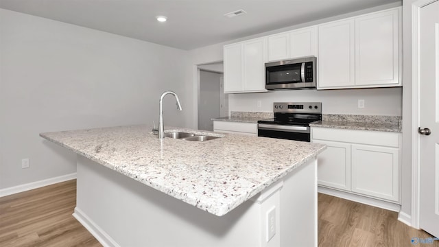 kitchen featuring appliances with stainless steel finishes, a kitchen island with sink, and white cabinets