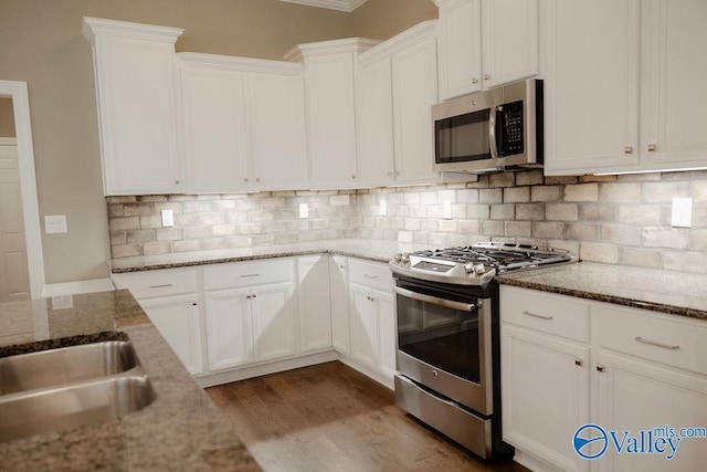 207 Somerton Dr, Huntsville, AL 35811 - kitchen with stainless steel appliances, dark wood-style flooring, white cabinetry, backsplash, and light stone counters