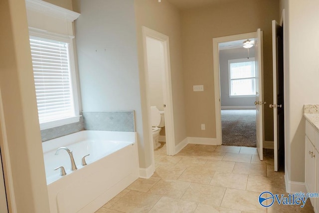 207 Somerton Dr, Huntsville, AL 35811 - full bath featuring vanity, a garden tub, toilet, a ceiling fan, and baseboards