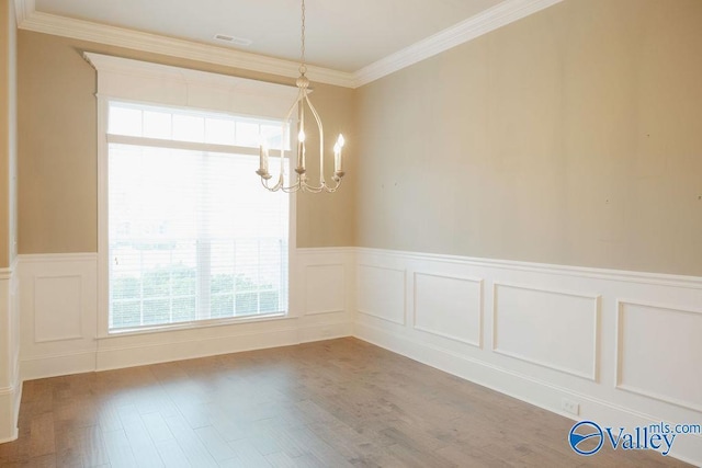 207 Somerton Dr, Huntsville, AL 35811 - unfurnished dining area featuring a chandelier, a decorative wall, wainscoting, ornamental molding, and wood finished floors