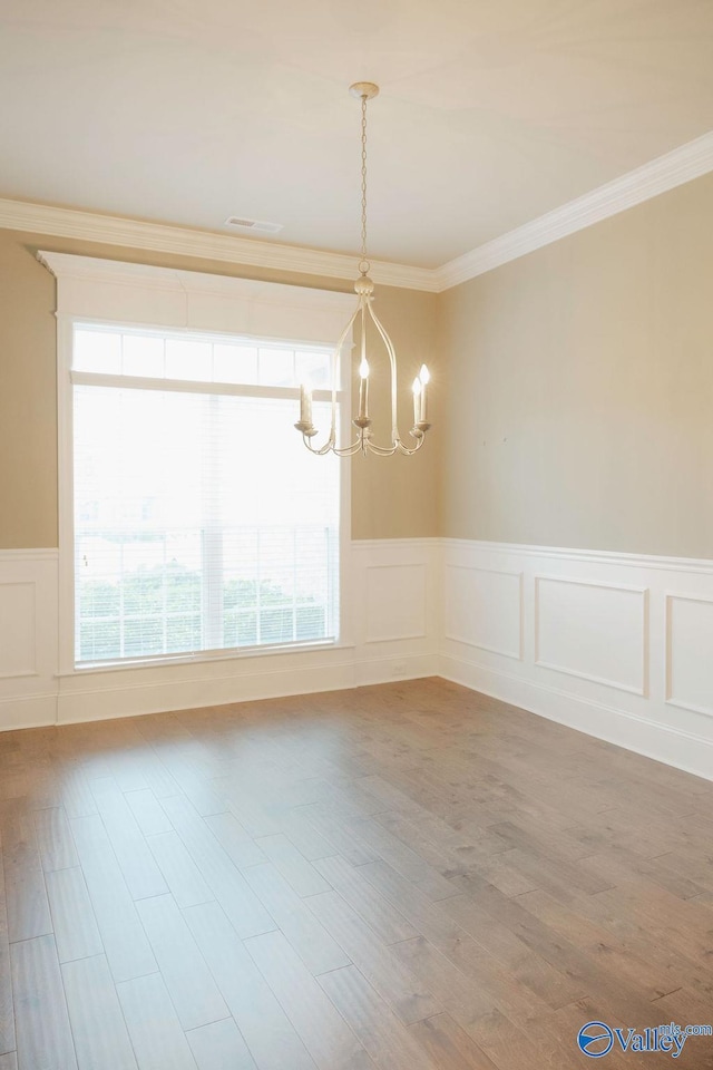 207 Somerton Dr, Huntsville, AL 35811 - unfurnished dining area with a chandelier, a decorative wall, crown molding, wainscoting, and wood finished floors