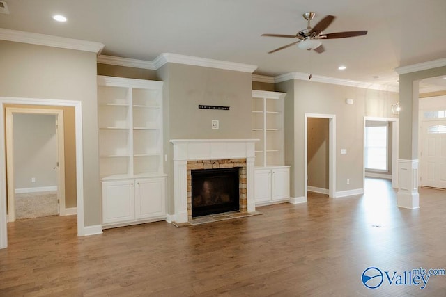 207 Somerton Dr, Huntsville, AL 35811 - unfurnished living room with a ceiling fan, crown molding, light wood finished floors, a stone fireplace, and baseboards