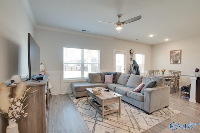 living room with ceiling fan, light hardwood / wood-style floors, and ornamental molding