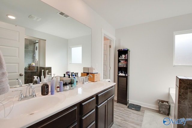 bathroom featuring a shower with door, vanity, and hardwood / wood-style flooring